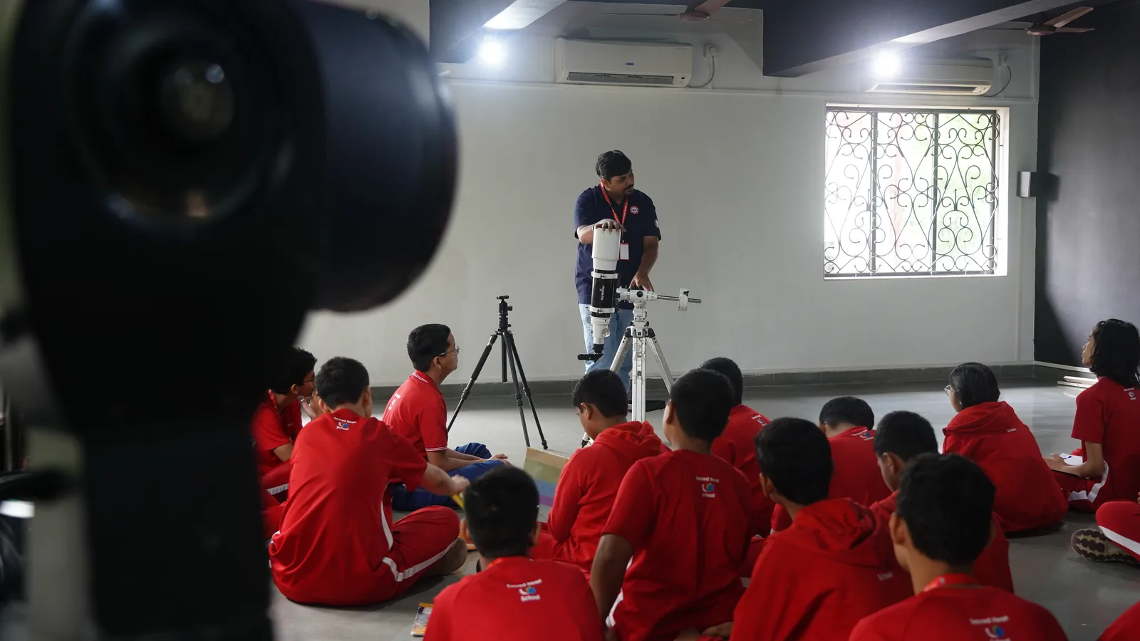 Students learning telescope technique indoors