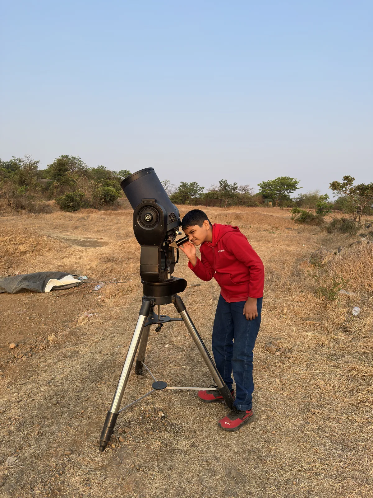 A student using a telescope outdoors