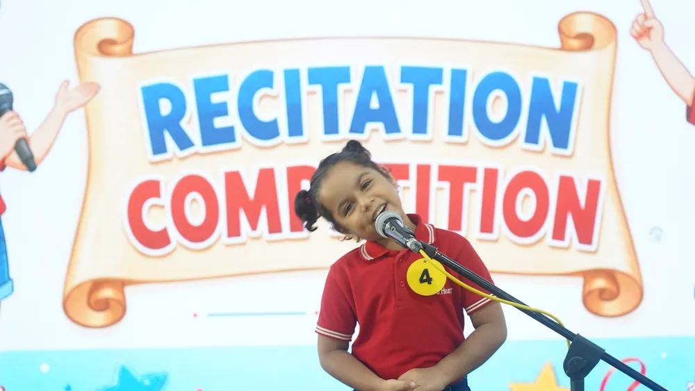 A Pre-Primary child reciting into a microphone at the Recitation Competition