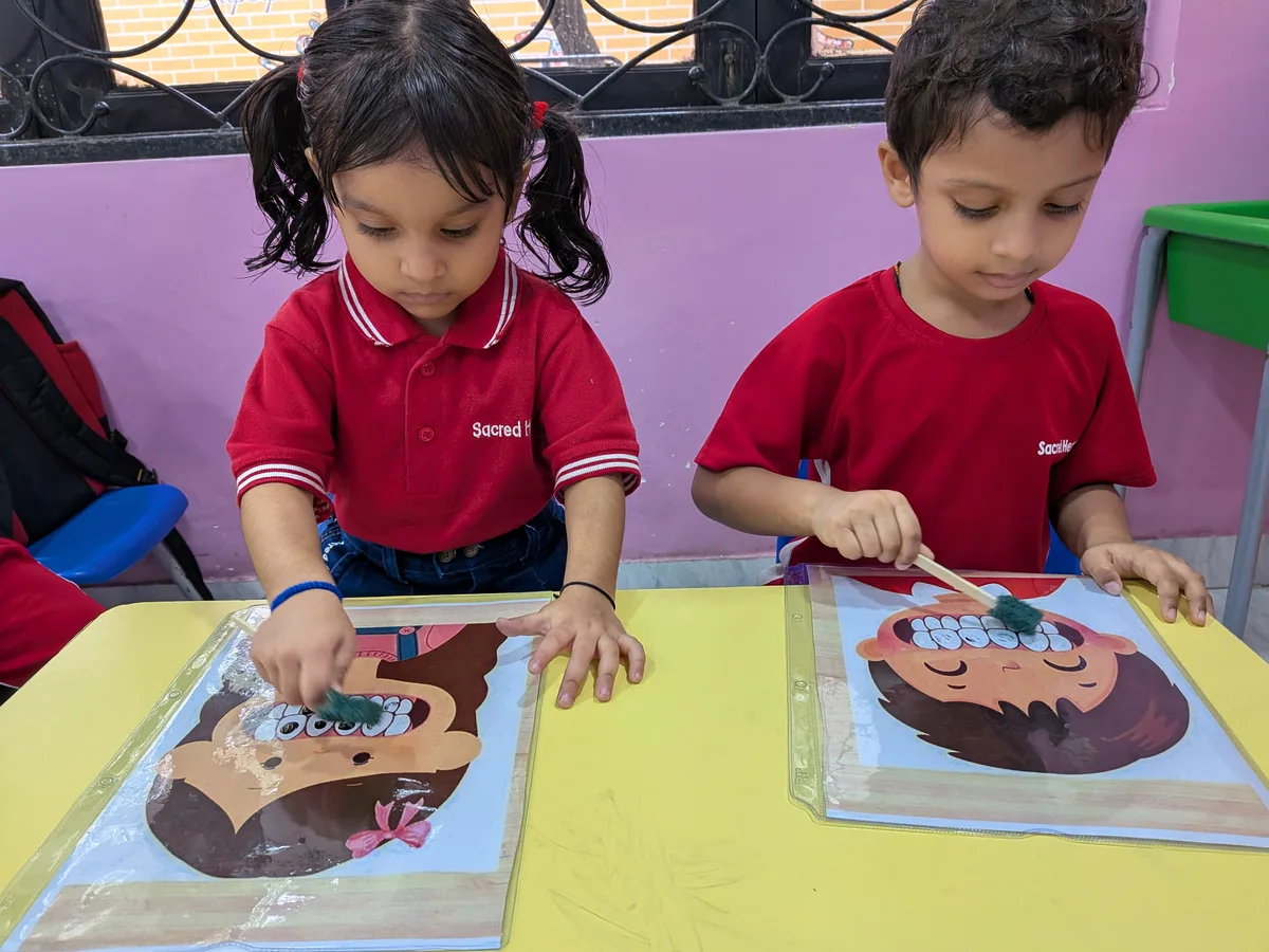 Two children working on a hands-on craft activity at a desk