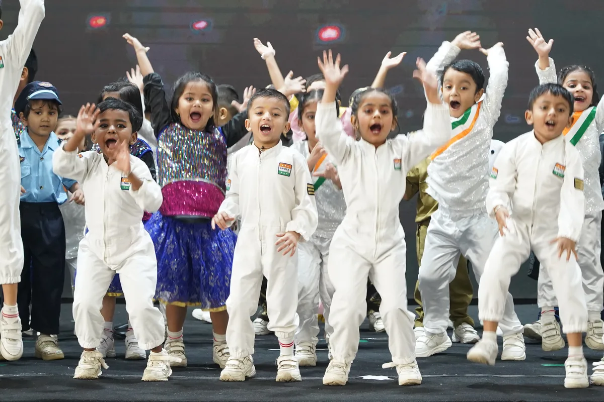 Pre-Primary children in white outfits celebrating on stage
