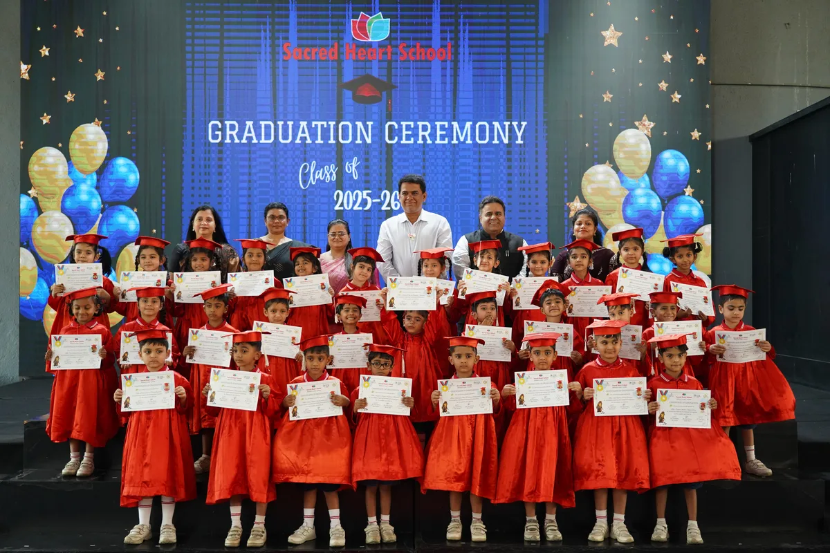 Senior Kindergarten graduates holding their certificates on stage