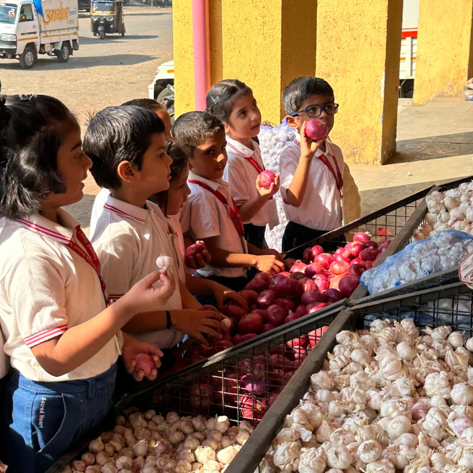 Pre-Primary children on a market visit, examining onions and garlic