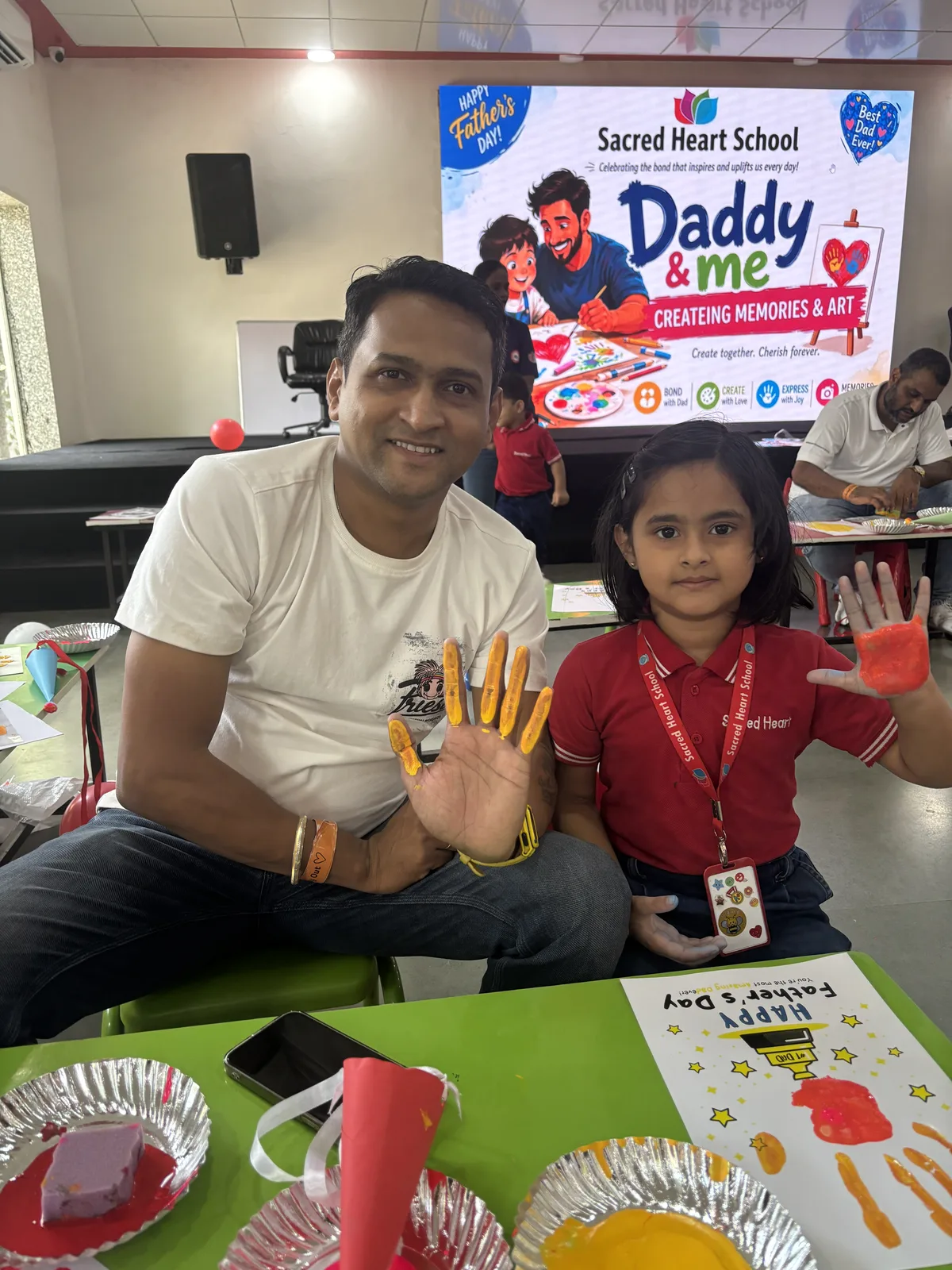 A parent and child at a 'Daddy & Me' handprint art activity
