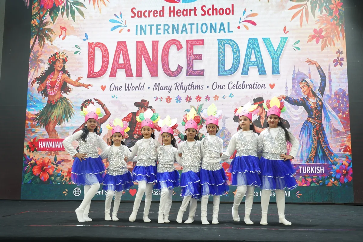 Primary students in blue and white costumes on the Dance Day stage