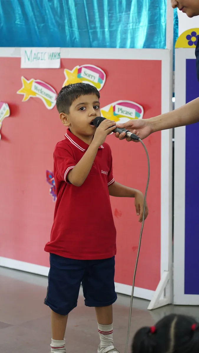 A Primary student speaking into a microphone at the puppet show