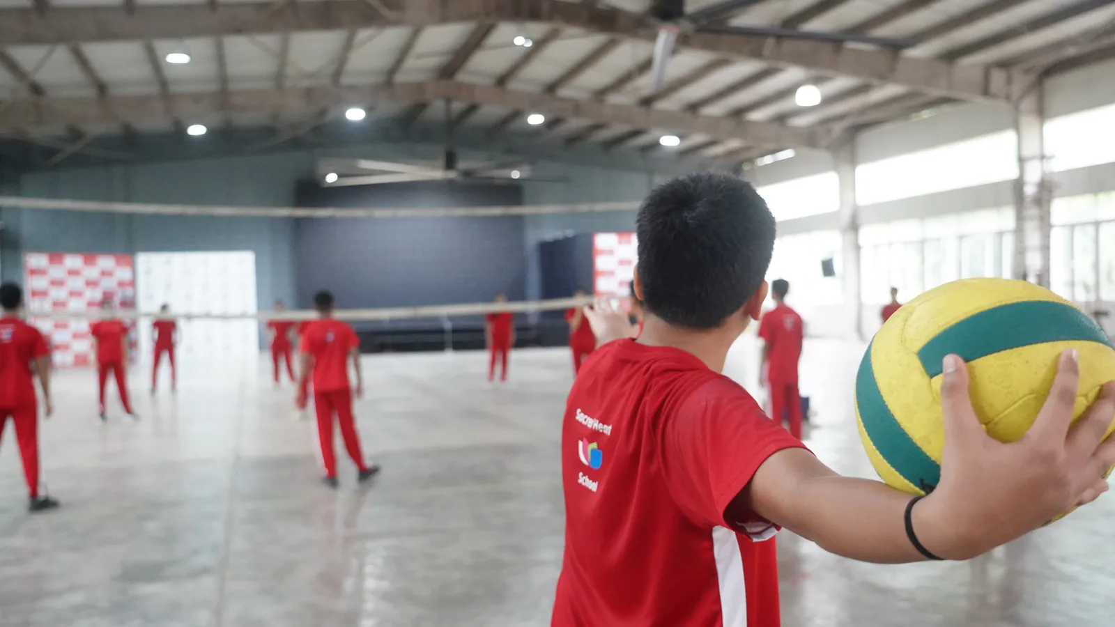 Students playing volleyball indoors