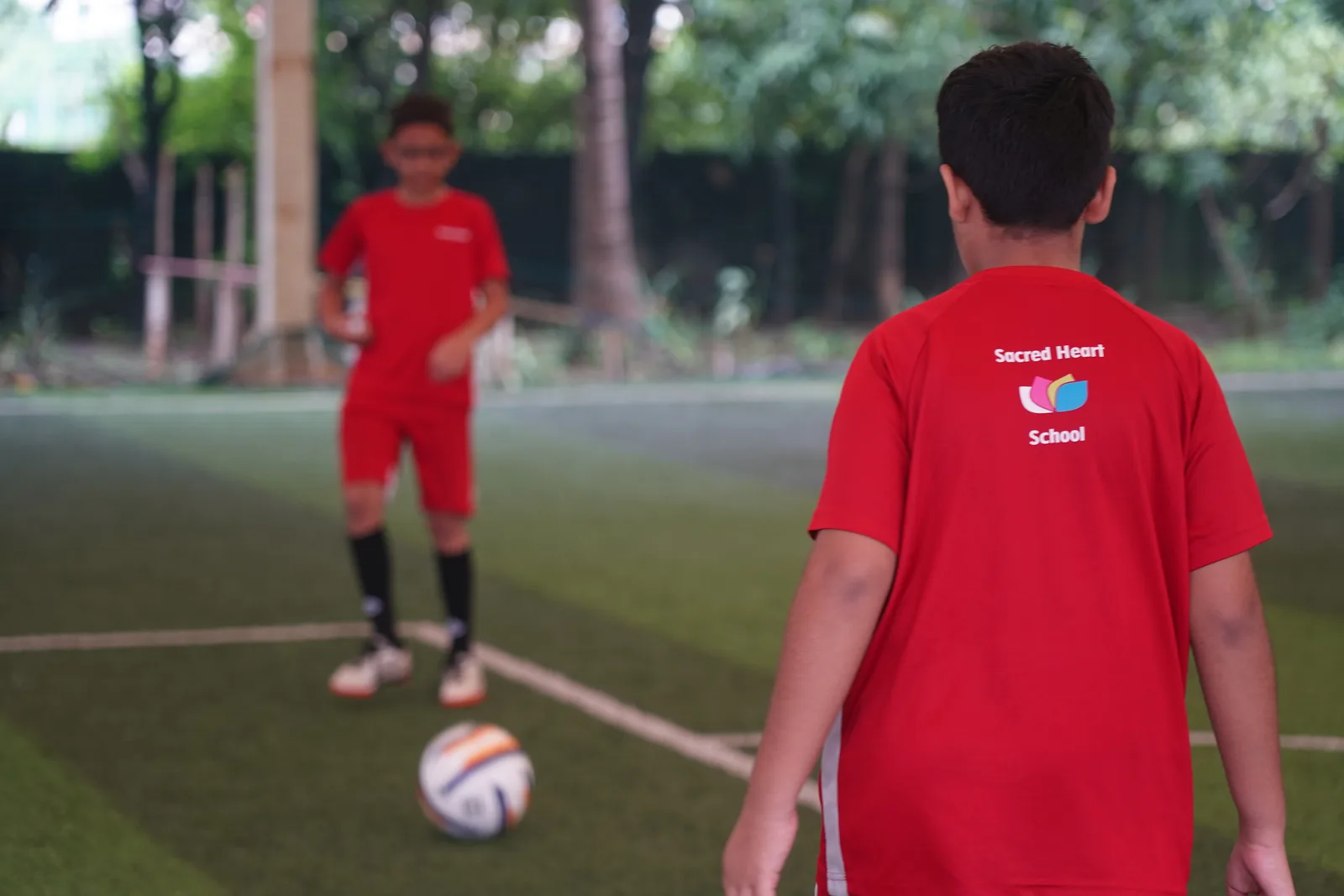 A student with a football on the turf