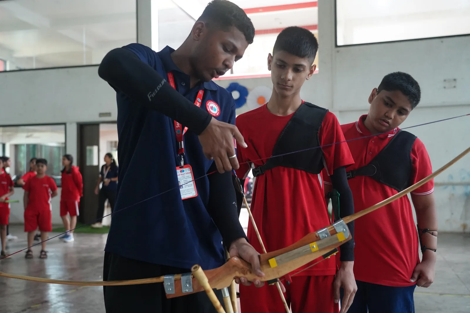 A coach teaching archery technique to students